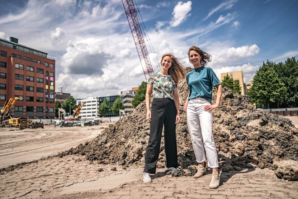 Twee huisartsen die in Amsterdam Zuid-oost een praktijk van de Toekomst willen beginnen gefotografeerd voor de bouwplaats waar hun praktijk komt